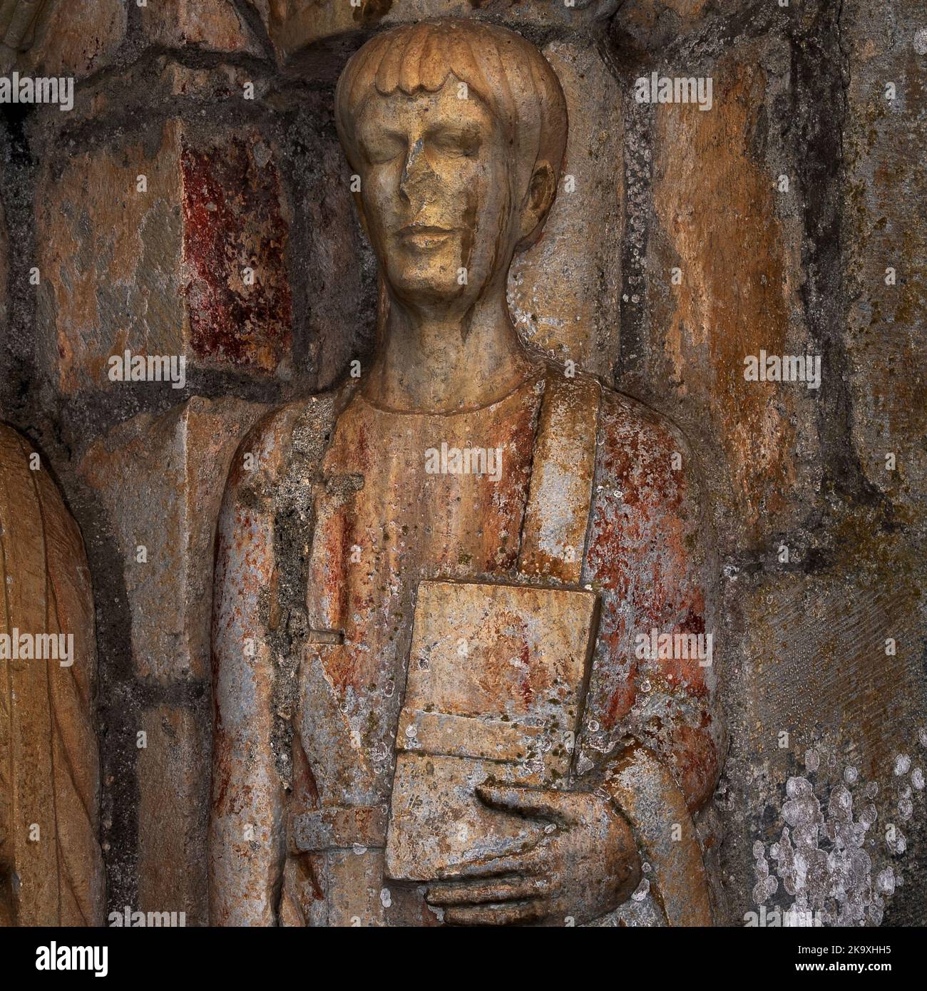 Vue carrée de la statue de Saint Pastor, un élève de 13 ans martyrisé par les Romains en Espagne. Statue de pilier dans le portail nord de la Basilique Saint-Just à Valcabrère, Occitanie, France. Banque D'Images