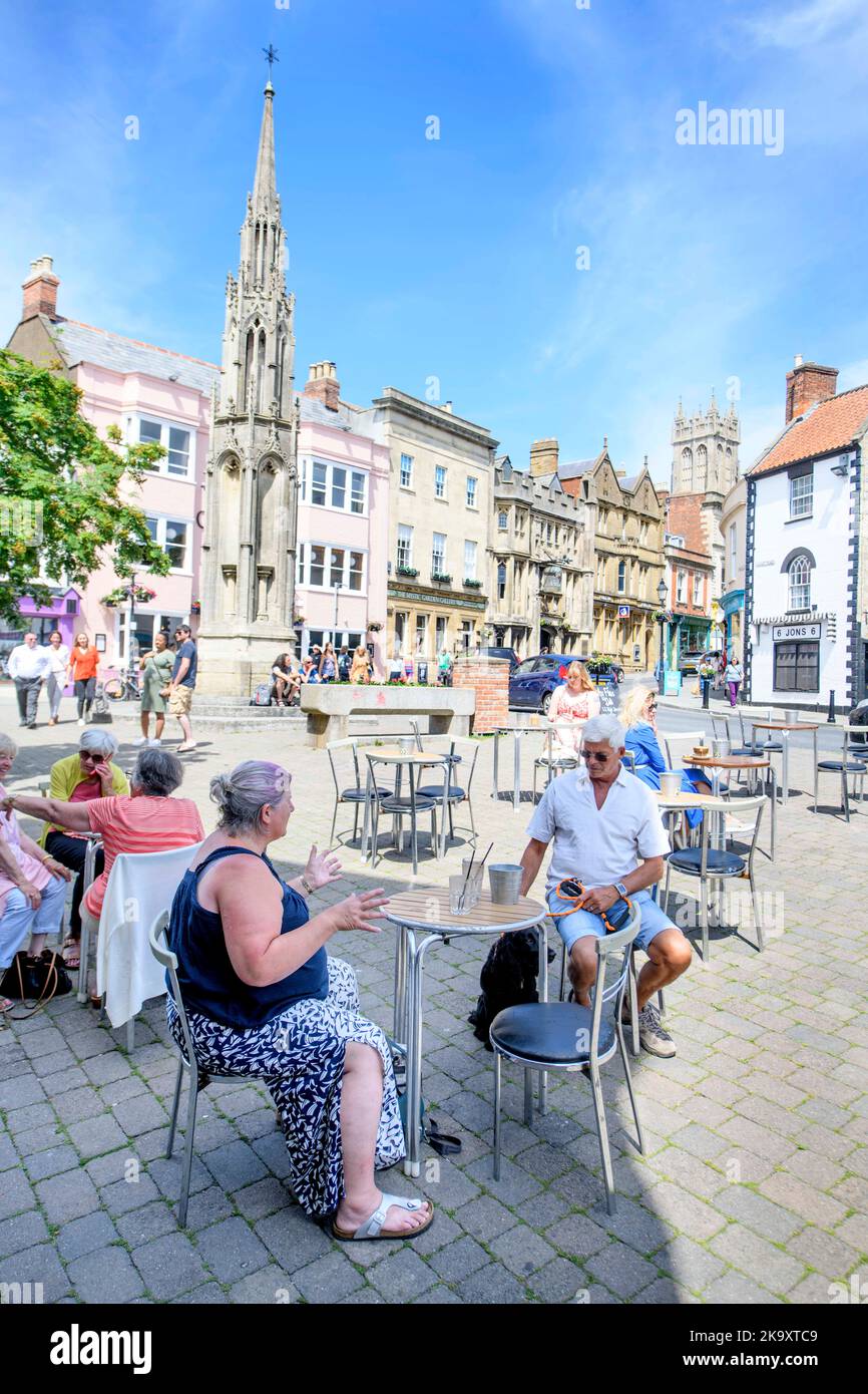 La ville de Glastonbury dans le Somerset avec un café de rue sur la place du marché et la croix du marché. Banque D'Images