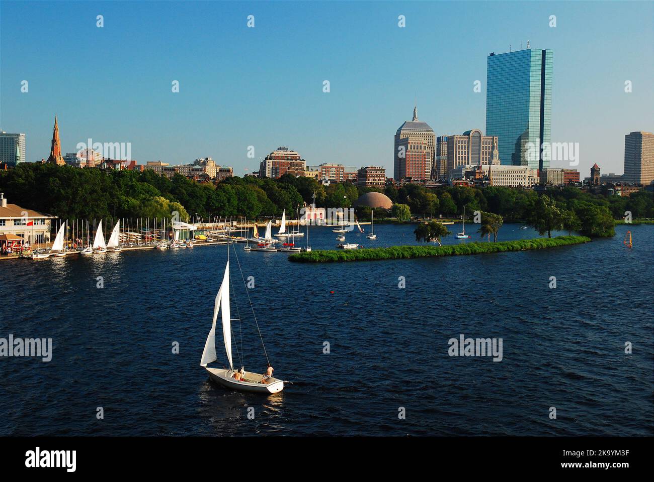 Une famille loue un voilier de Community Boating et profite d'une journée de vacances d'été ensoleillée en train de se prélamer sur l'eau de la rivière Charles dans un bateau à Boston Banque D'Images