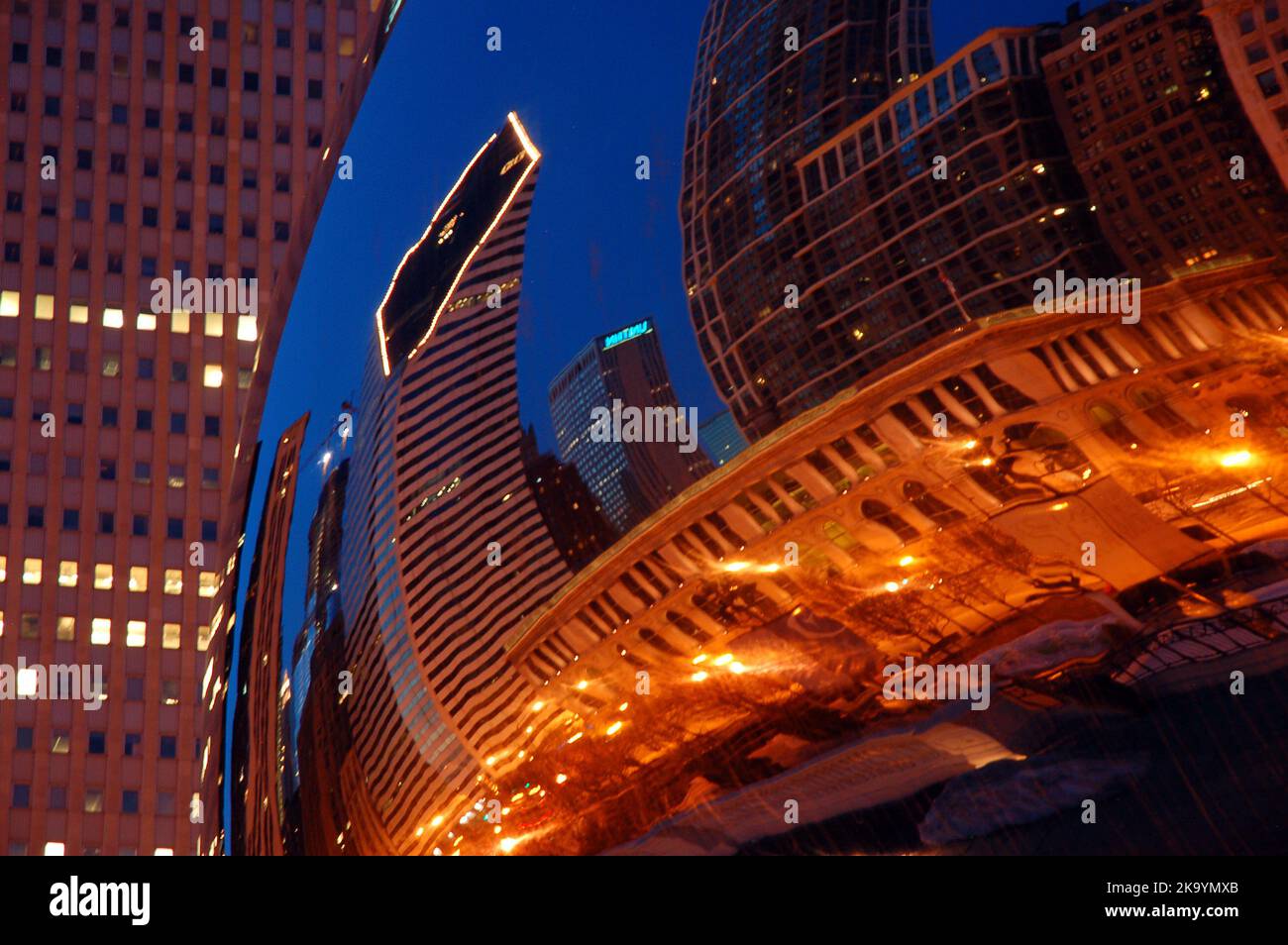 Cloud Gate, plus connu sous le nom de Bean, reflète les structures et les lumières de la ligne d'horizon de Chicago depuis Millennium Park Banque D'Images
