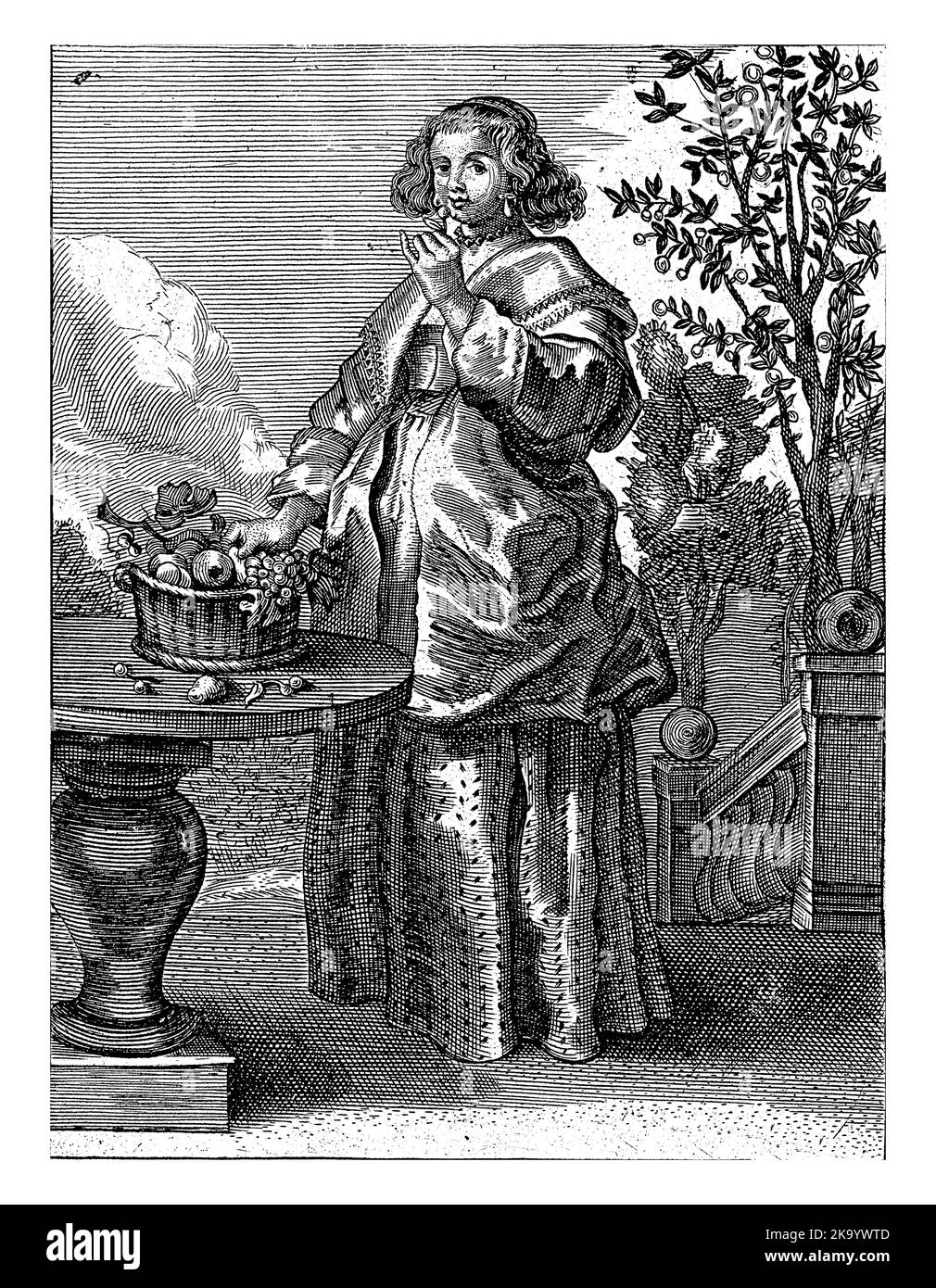 Personnification du sens du goût. Une femme mange des fruits du panier de fruits sur la table devant elle. Banque D'Images