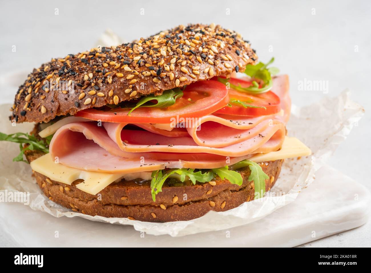 bagel rempli de jambon, fromage à la crème et tomate Banque D'Images