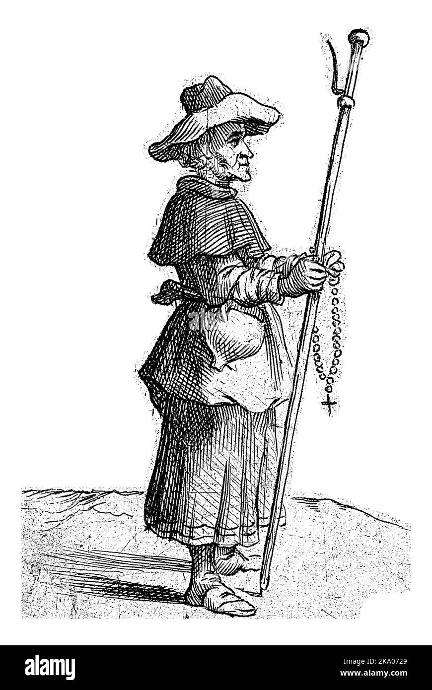 Un pèlerin avec un personnel et des perles de prière dans ses mains et un chapeau sur sa tête. Banque D'Images