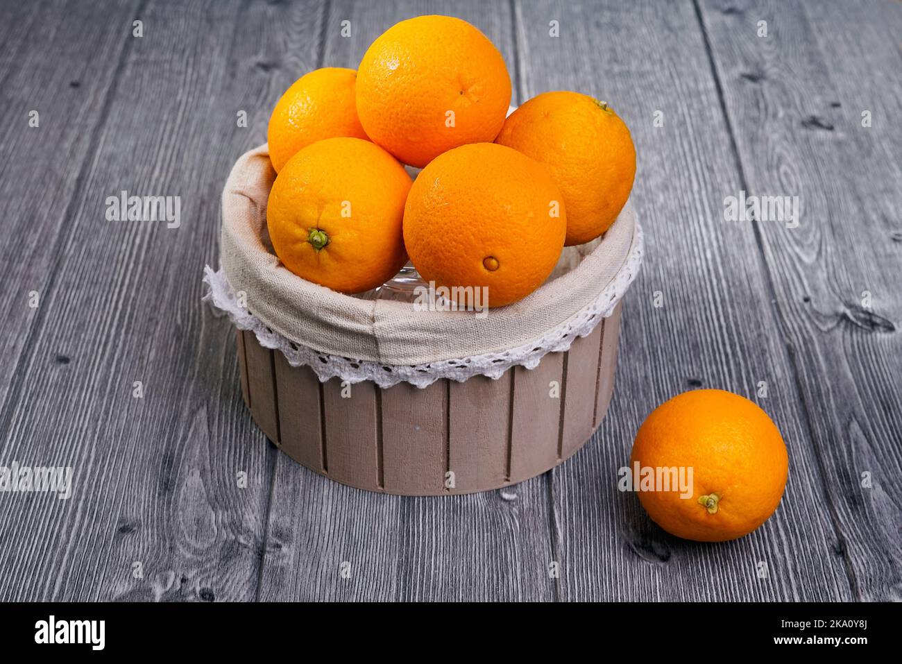 Panier d'oranges sur fond de bois Banque D'Images