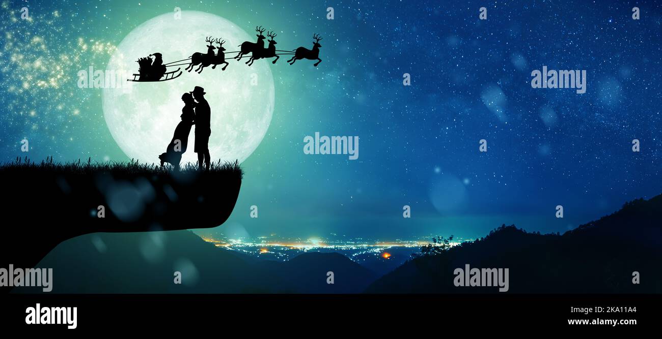 Silhouette du Père Noël faites un tour sur leur renne sur toute la lune le soir de Noël. Un couple dansant sous la pleine lune. Banque D'Images