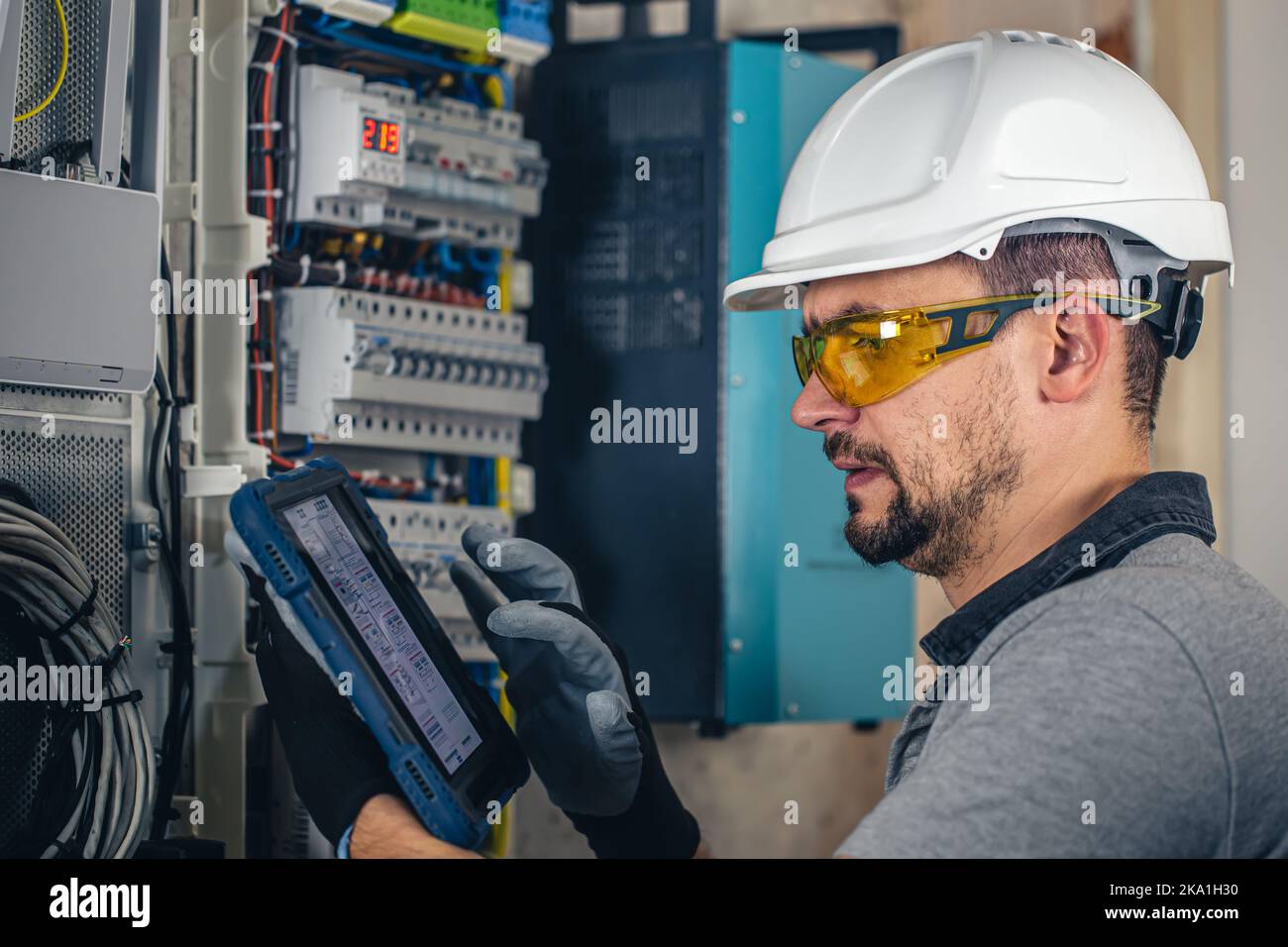 Man, un technicien en électricité travaillant dans un tableau de commutation avec des fusibles. Banque D'Images
