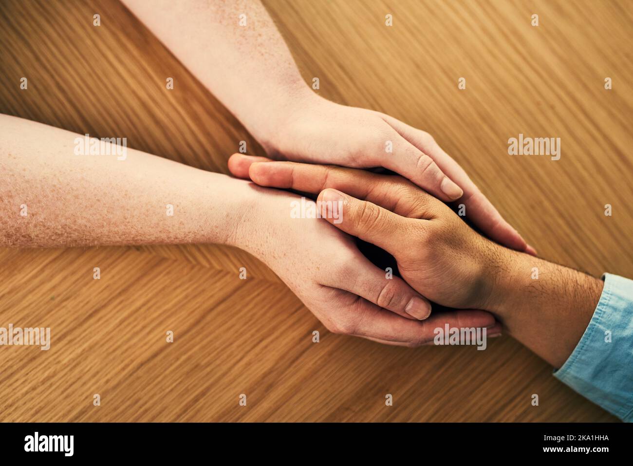 Vous êtes maintenant dans un espace sûr. Un homme et une femme tenant les mains confortablement sur une table. Banque D'Images