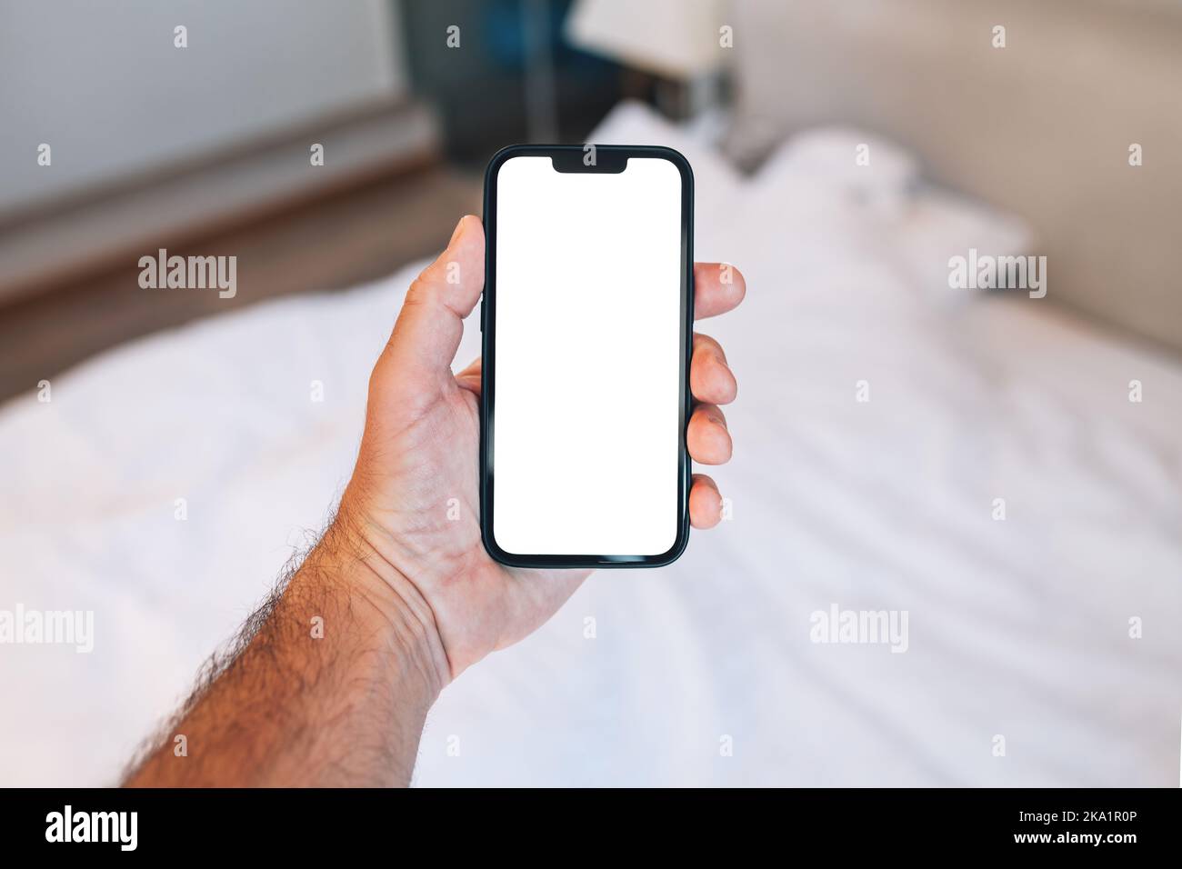 Touriste dans la chambre d'hôtel avec smartphone avec écran vide pour la réservation et l'application de réservation ou le service de classification d'hébergement Banque D'Images