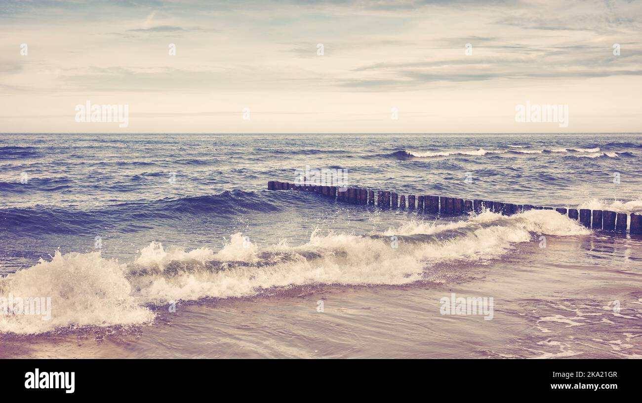 Image dans un style rétro d'une plage vide avec une vague en panne. Banque D'Images