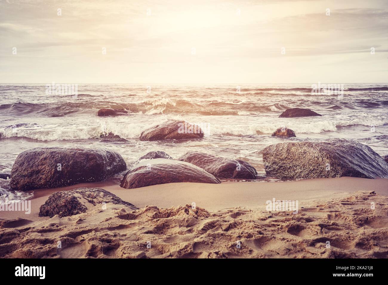 Rochers sur une plage de sable, teintes rétro appliquées. Banque D'Images
