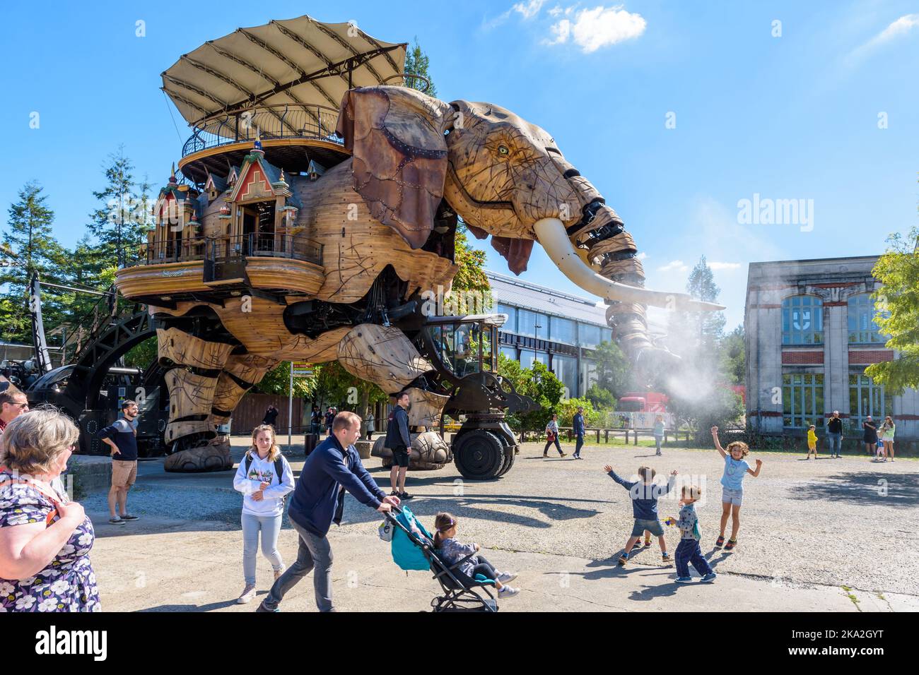 La marionnette géante du Grand Eléphant, qui fait partie des machines de l'attraction touristique de l'île de Nantes, pulvérise de l'eau avec son tronc sur les enfants excités. Banque D'Images
