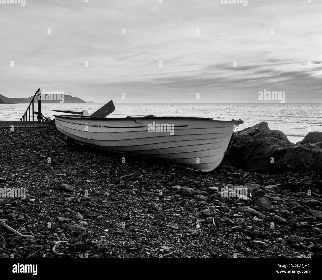 Paysage d'un bateau sur une rive sous un ciel nuageux en noir et blanc à Wellington, Nouvelle-Zélande. Banque D'Images