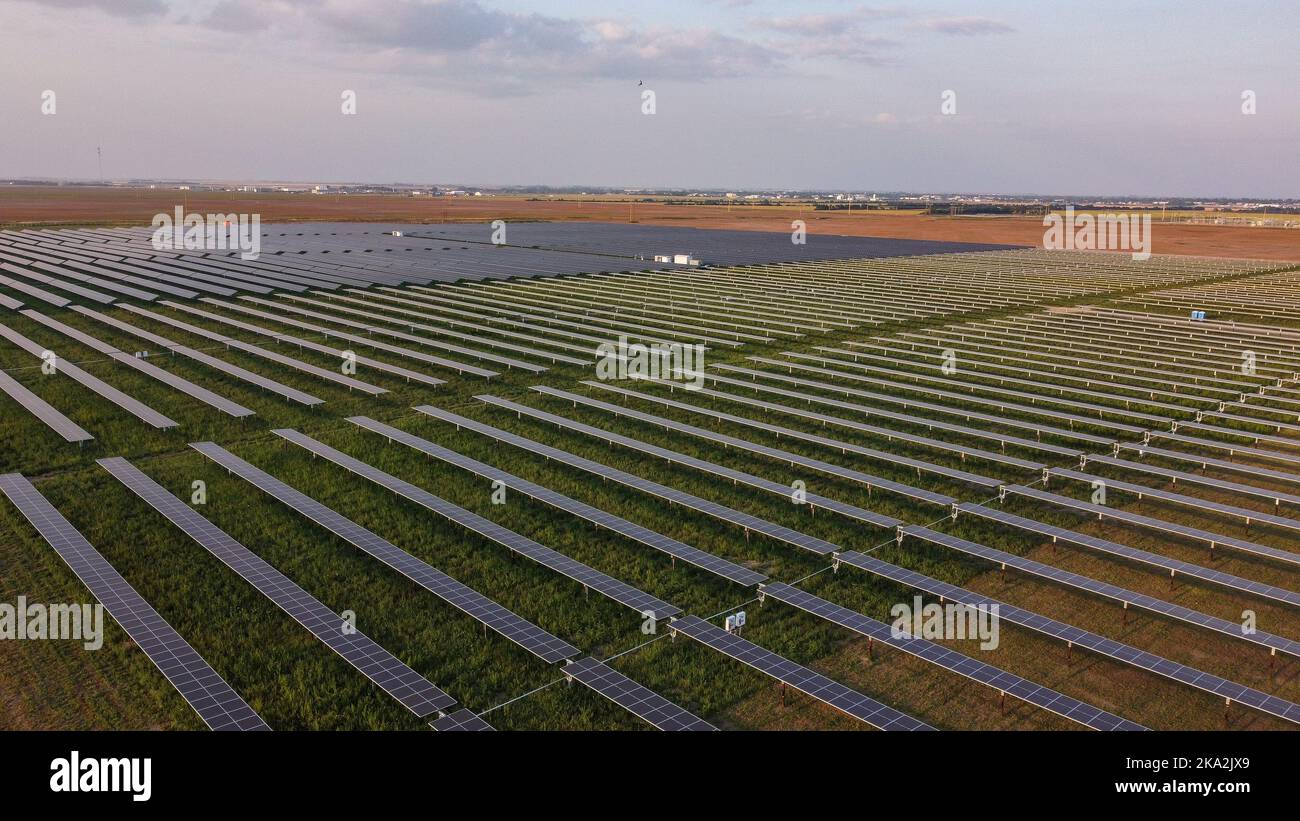 Une vue aérienne des panneaux solaires avec de vastes champs en arrière-plan Banque D'Images