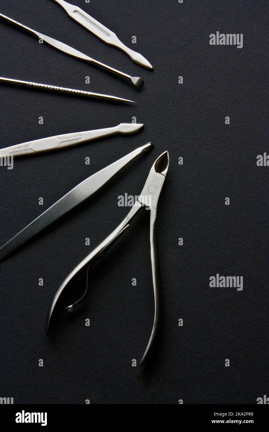 Ensemble de clous en acier sur fond noir. Photo promotionnelle du kit d'art pour les ongles de l'ensemble de beauté. Banque D'Images
