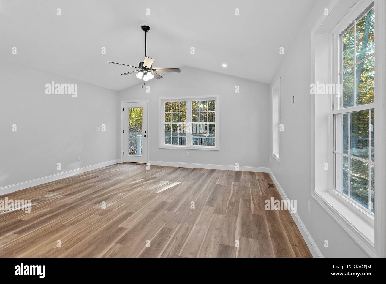 Une vue intérieure sur une maison récemment construite avec des murs blancs, de grandes fenêtres et un parquet Banque D'Images