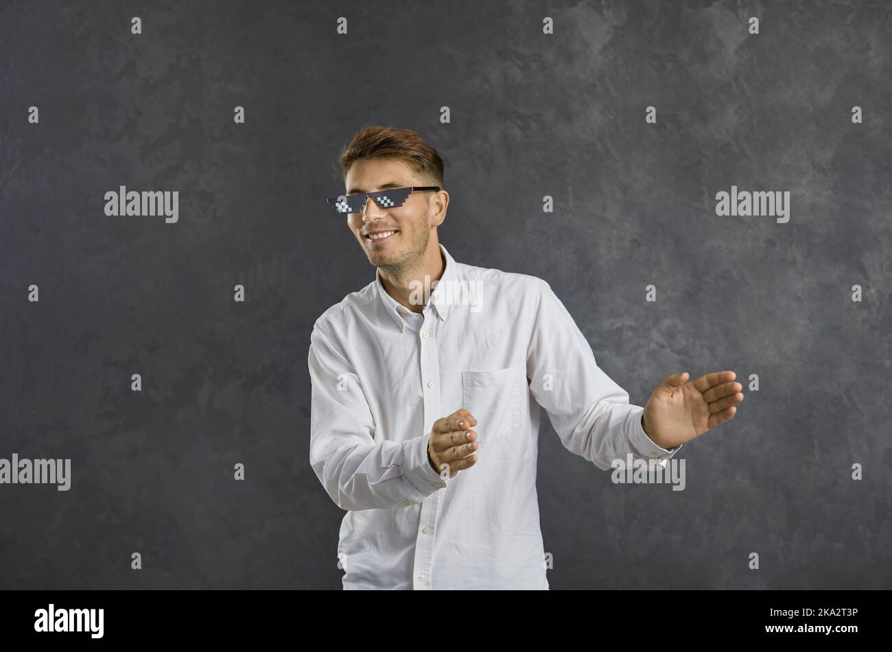 Drôle heureux jeune gars dans la vie moderne de thoug pixel lunettes de soleil dansant et appréciant la musique Banque D'Images