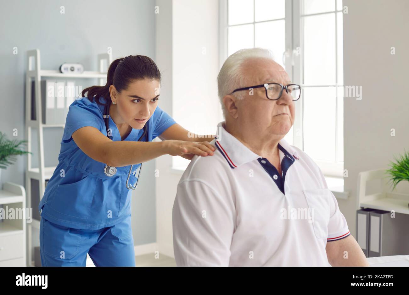 Chiropraticien ou physiothérapeute examinant un patient mâle senior avec des problèmes de colonne vertébrale Banque D'Images