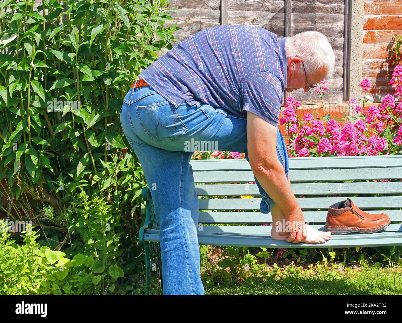 Homme âgé ou âgé souffrant de douleurs au pied. Soit blessure par accident de l'arthrite. En tenant le pied et dans l'agonie. Banque D'Images