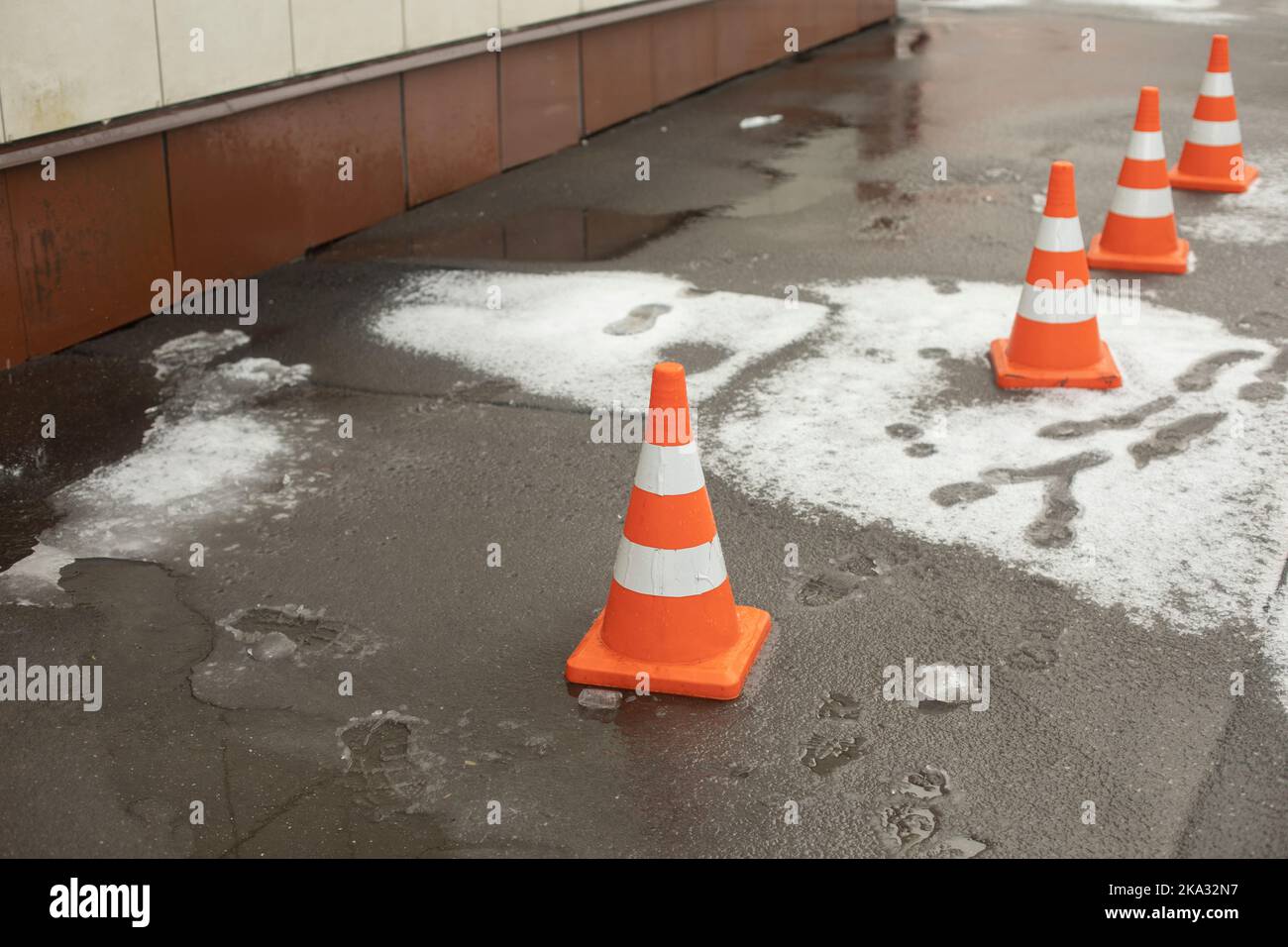Cache de dissimulation sur l'asphalte. Zone d'urgence. Chute de neige du toit. Zone clôturée des piétons. Banque D'Images