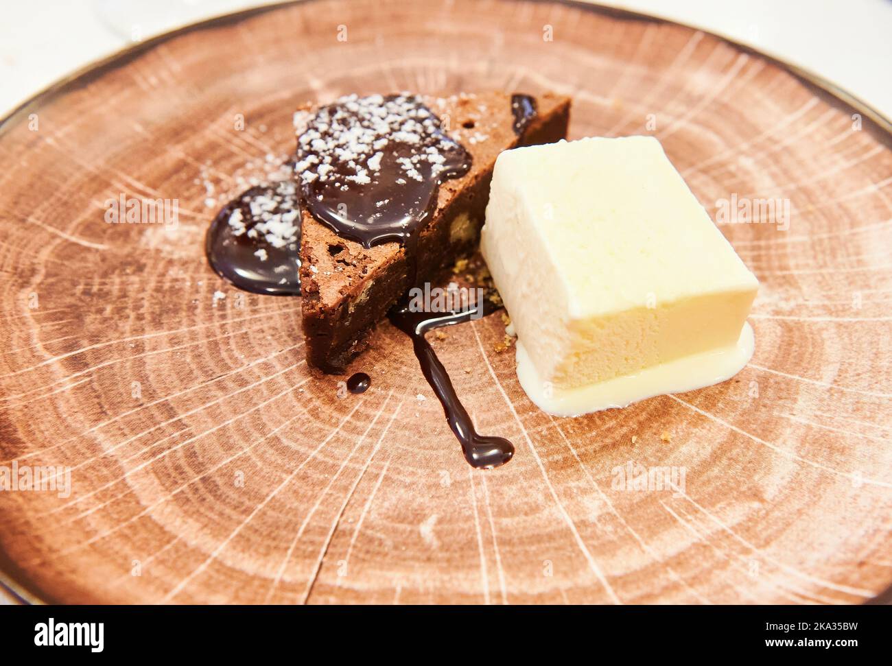 Dessert au chocolat et crème glacée à la vanille sur une assiette en bois imitation Banque D'Images