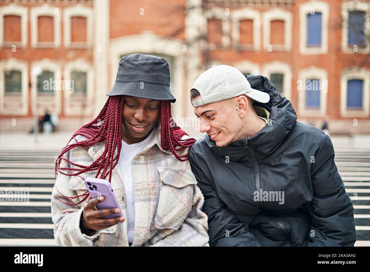 Portrait d'un couple multiethnique au téléphone, dans la rue Banque D'Images