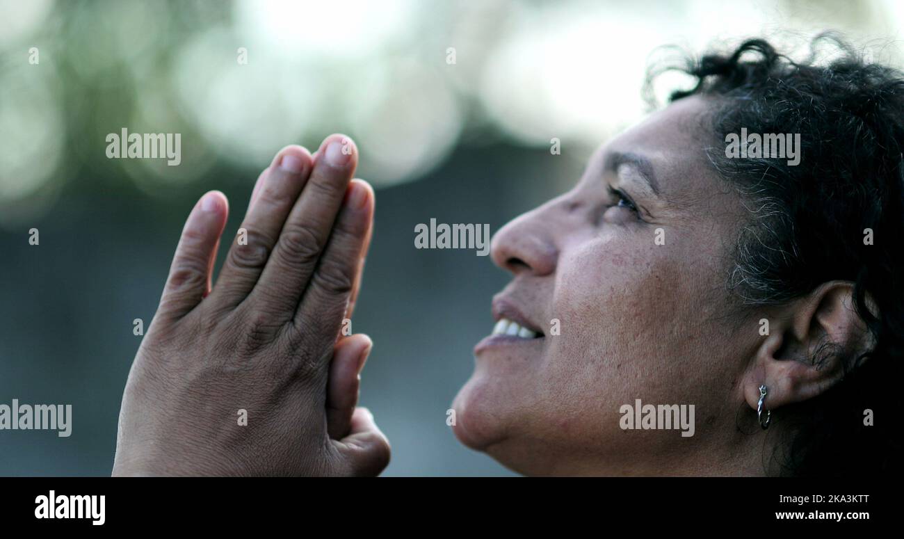 Femme brésilienne évangélique priant à Dieu. Personne spirituelle mature qui louait Dieu Banque D'Images