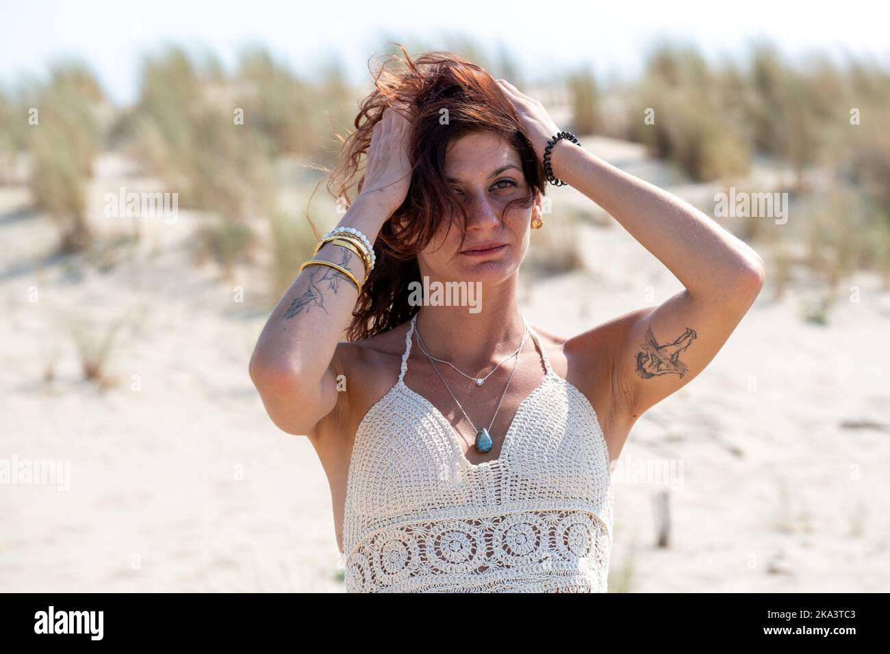 Belle femme debout sur la plage avec ses mains dans ses cheveux, France Banque D'Images