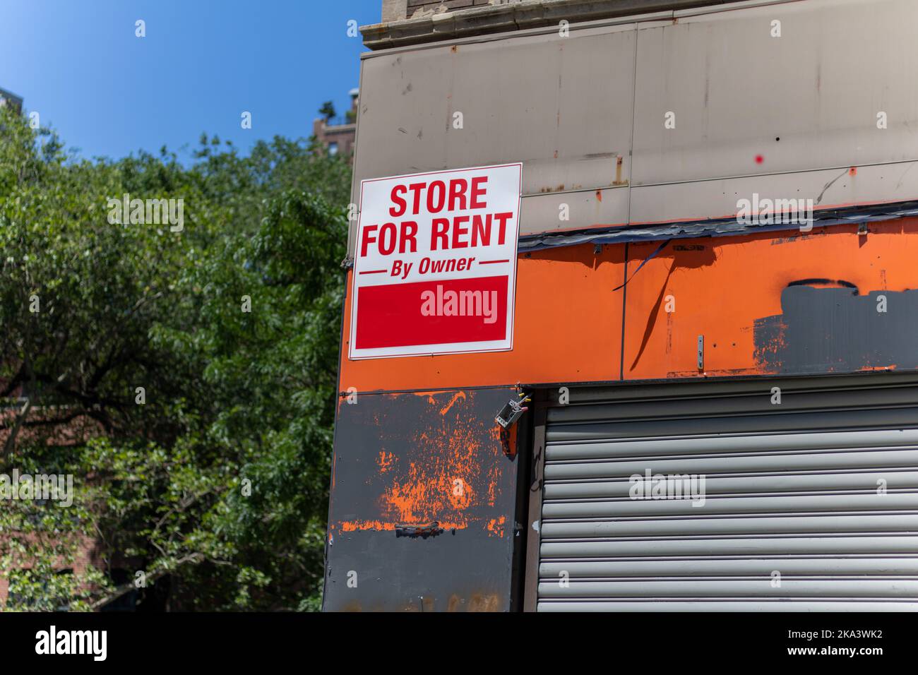Un gros plan d'une tablette avec inscription « Store with Rent » sur un magasin délabré avec peinture à l'orange qui s'écaille Banque D'Images