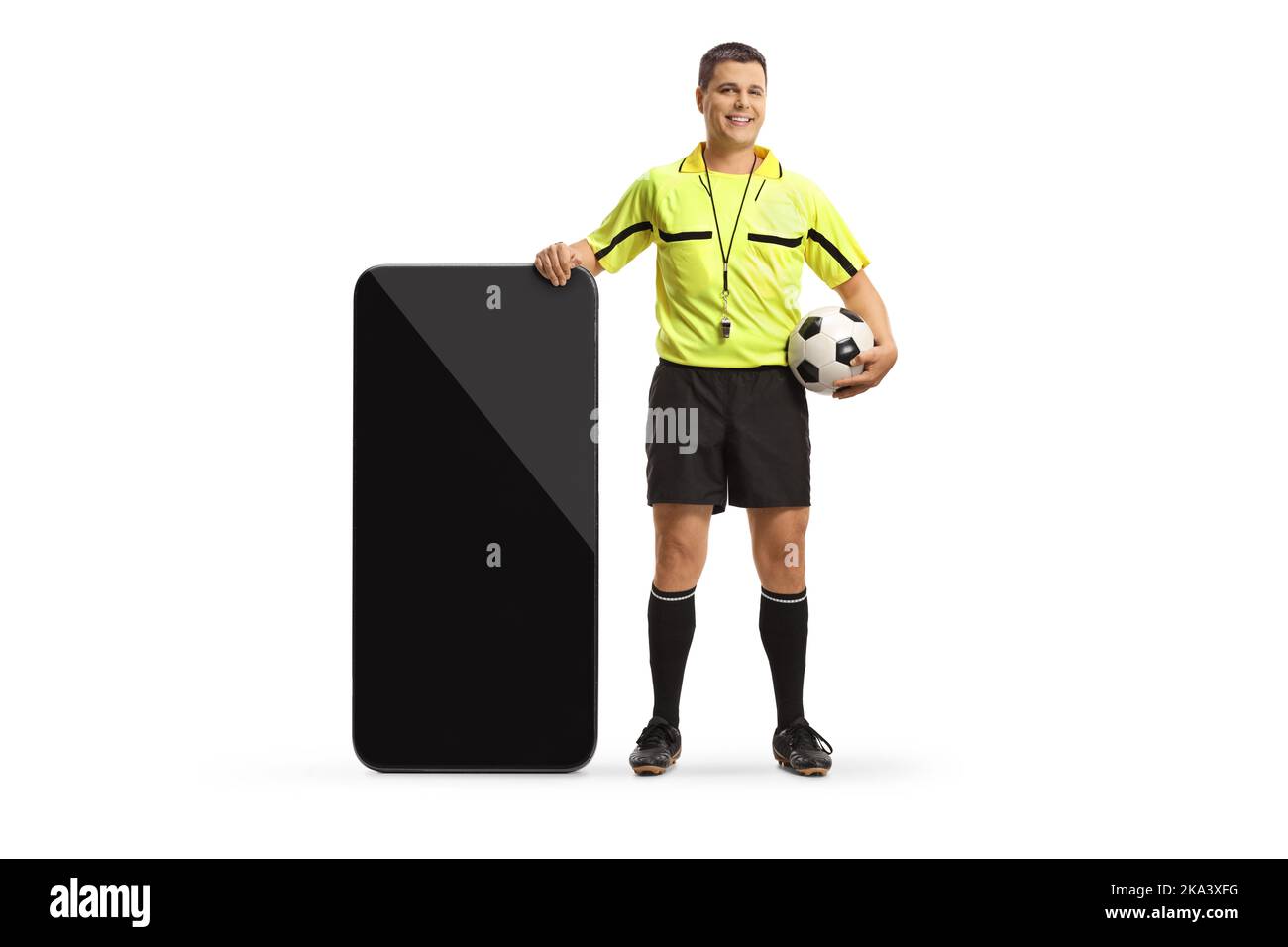 Portrait complet d'un arbitre de football debout à côté d'un grand smartphone isolé sur fond blanc Banque D'Images