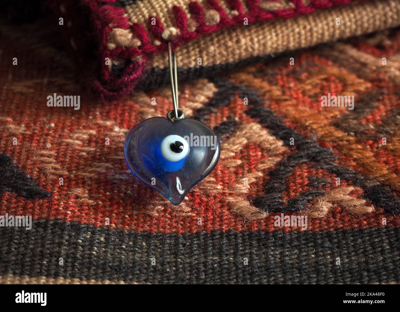 Perles oeil mauvais sur des motifs turcs. Perle œil mal en verre en forme de coeur. Banque D'Images
