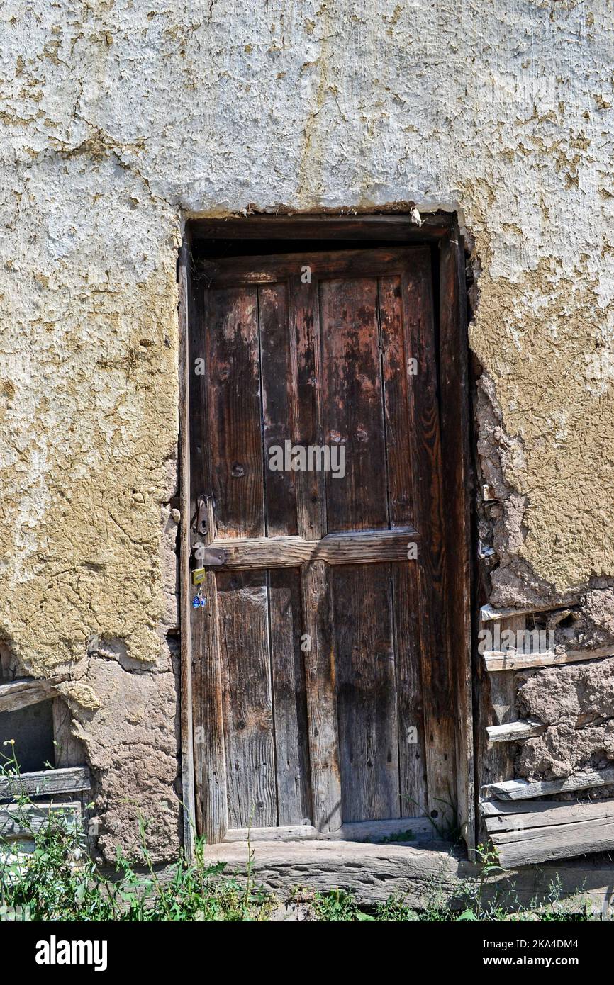 Une verticale d'une porte en bois usée et abîmée d'une maison rurale semi-effondrée Banque D'Images