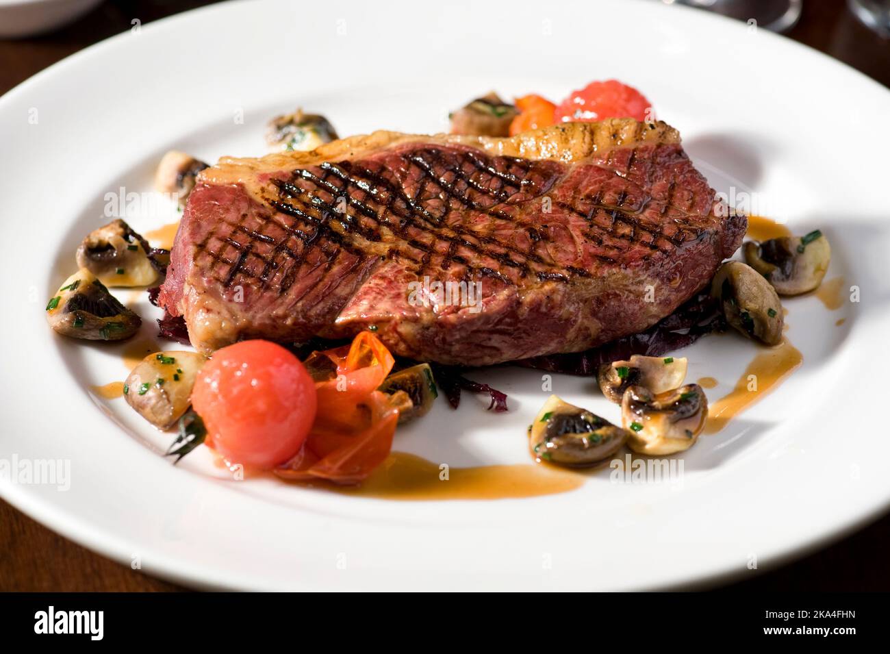 Steak servi avec des champignons et des tomates cerises Banque D'Images