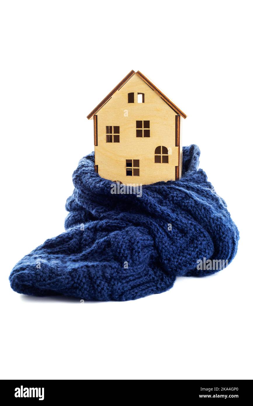 La maison de jouets en bois est enveloppée dans un foulard chaud isolé sur fond blanc Banque D'Images