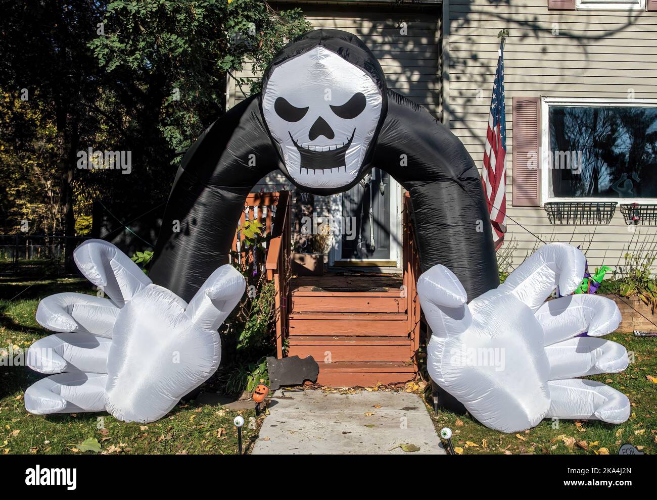 Un ballon d'Halloween effrayant avec un crâne et des bras avec de grandes mains blanches qui s'écartent d'un porche sur une maison le jour d'automne à Osceola, Wisconsin, États-Unis. Banque D'Images