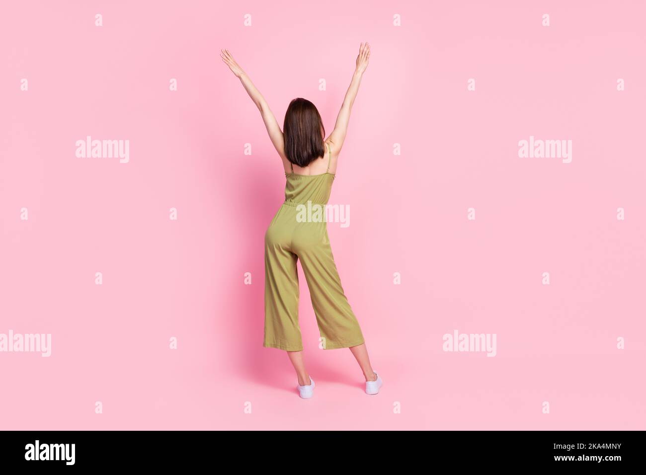 Pleine longueur corps taille rare vue photo de la adorable dame vêtue kaki vêtements de main en agitant isolé sur fond rose vif couleur Banque D'Images