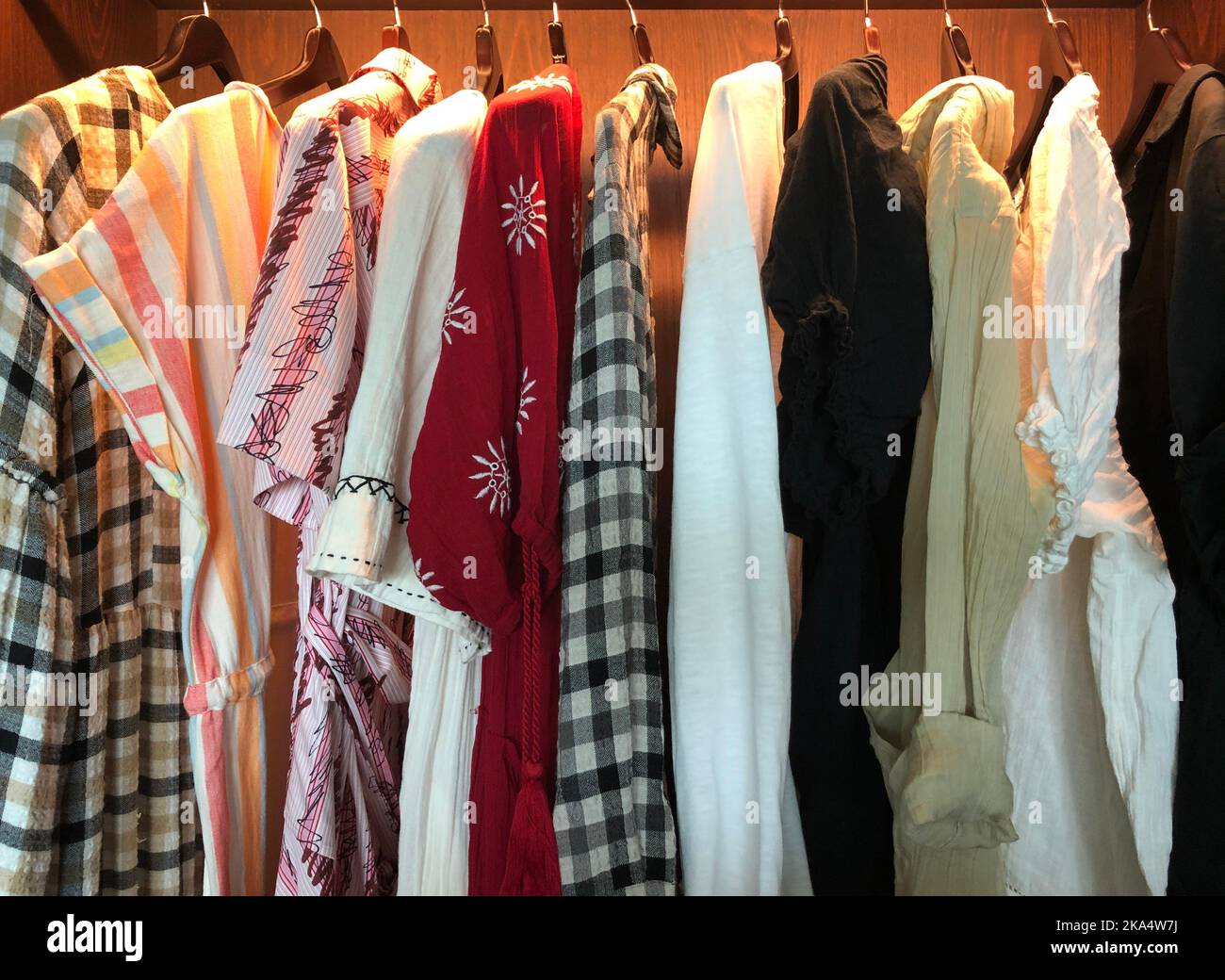 Gros plan des vêtements pour femmes suspendus dans une armoire lumineuse Banque D'Images