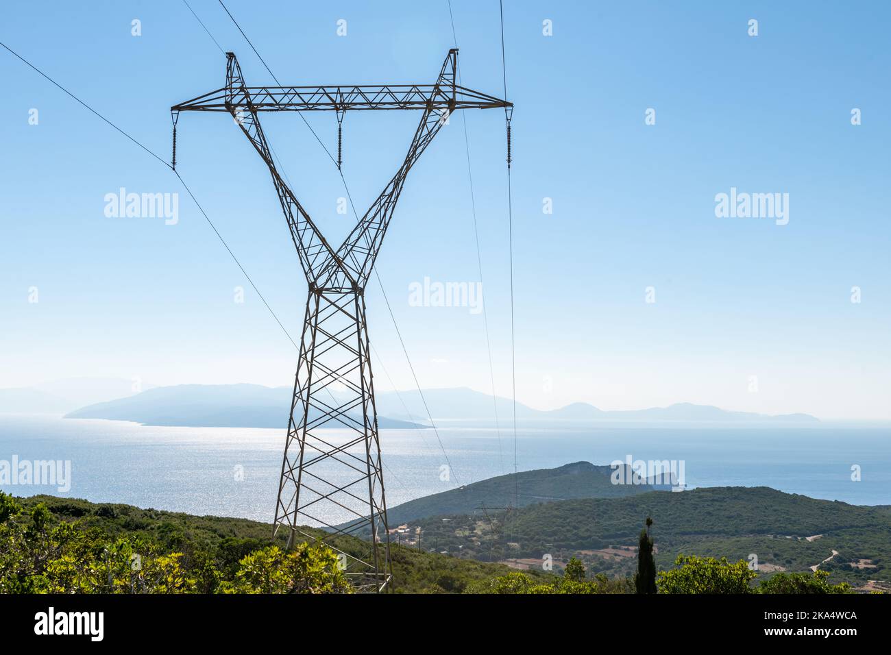 Une tour de transport d'électricité avec vue sur la mer et l'île. Banque D'Images