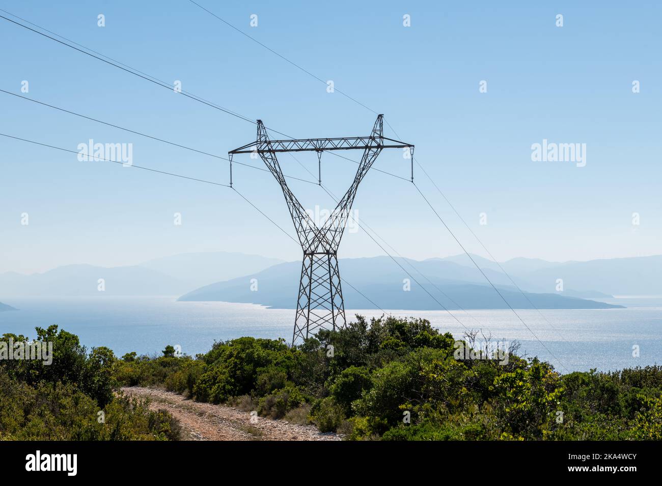 Une tour de transport d'électricité avec vue sur la mer et l'île. Banque D'Images