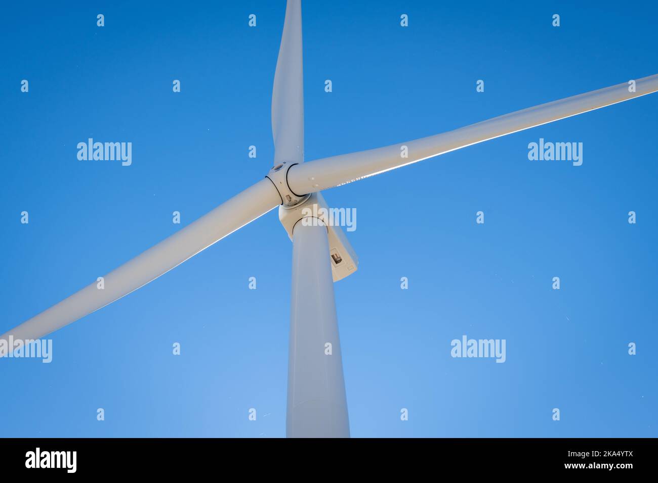 Vue rapprochée des pales en rotation et de la tête d'une éolienne. Banque D'Images