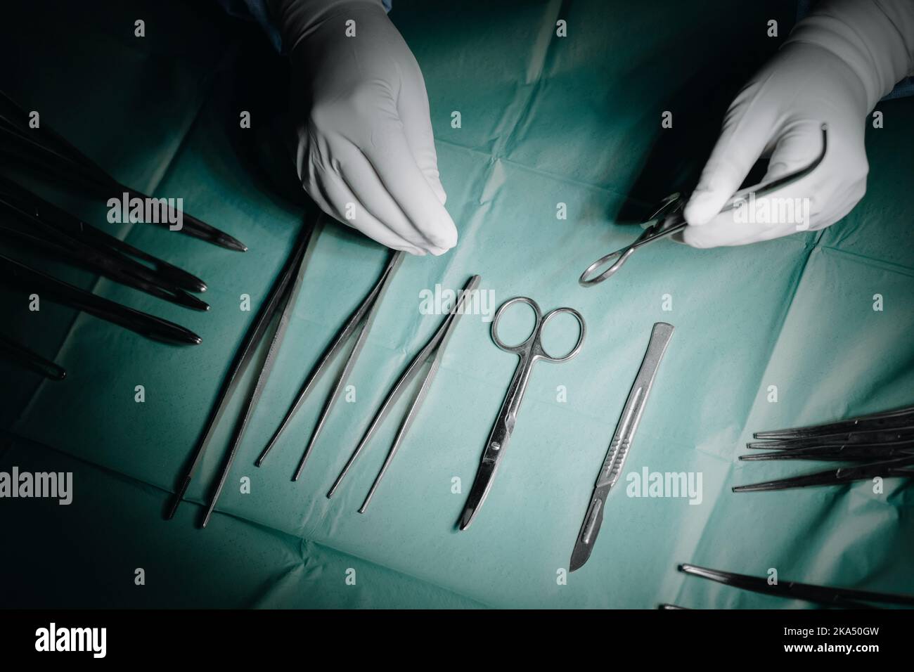 La main du médecin prend un instrument chirurgical de la table Banque D'Images