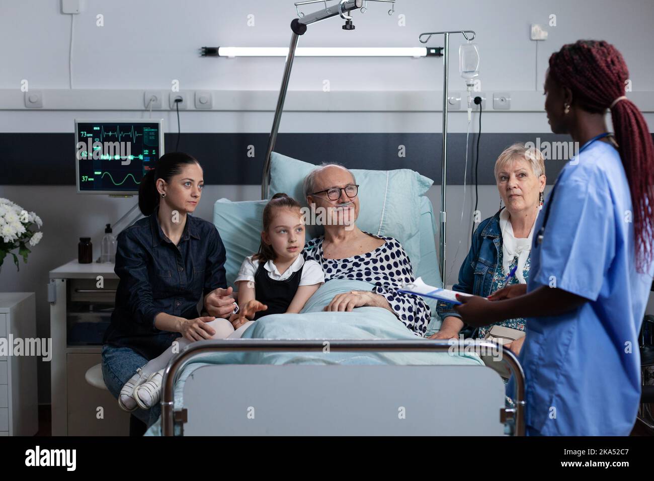 Une infirmière praticienne rédige une ordonnance pour un patient âgé souffrant de problèmes respiratoires. Grand-père malade famille à l'écoute diagnostic d'un médecin afro-américain à la salle d'observation de clinique médicale. Banque D'Images