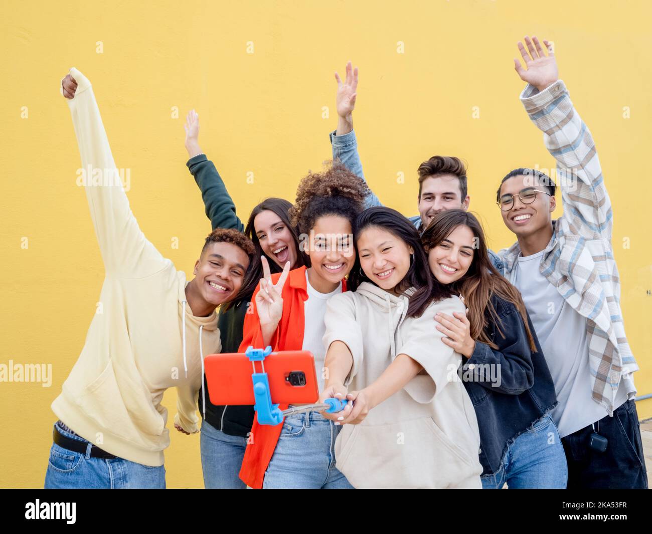 Groupe de membres de la génération du millénaire qui enregistrent une vidéo ou prennent une photo sur les réseaux sociaux. Les jeunes s'amusent avec les nouvelles technologies Banque D'Images