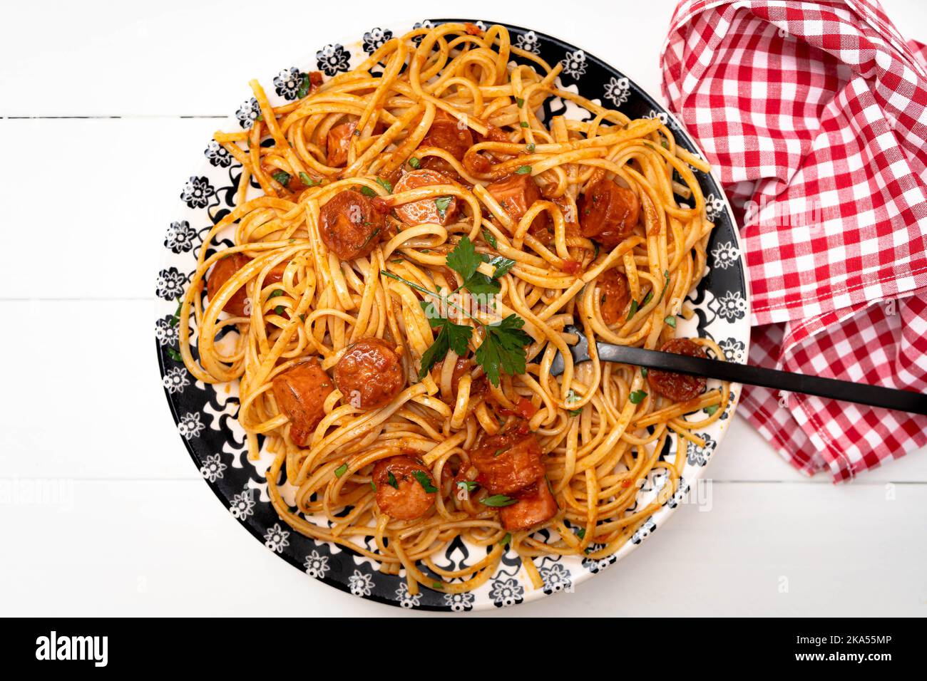 Copieux plat de pâtes italiennes avec sauce tomate et saucisse avec sauce sur une table blanche rustique. Vue de dessus. Banque D'Images