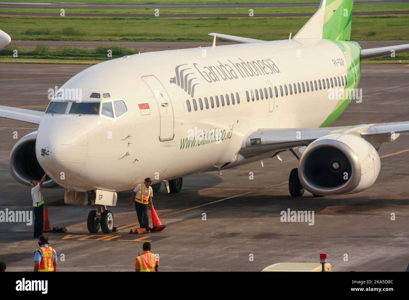 Vue du transporteur à bas prix Citilink de Garuda Indonesia sur un tablier avec équipage au sol à l'aéroport international de Juanda avec piste en arrière-plan. Banque D'Images