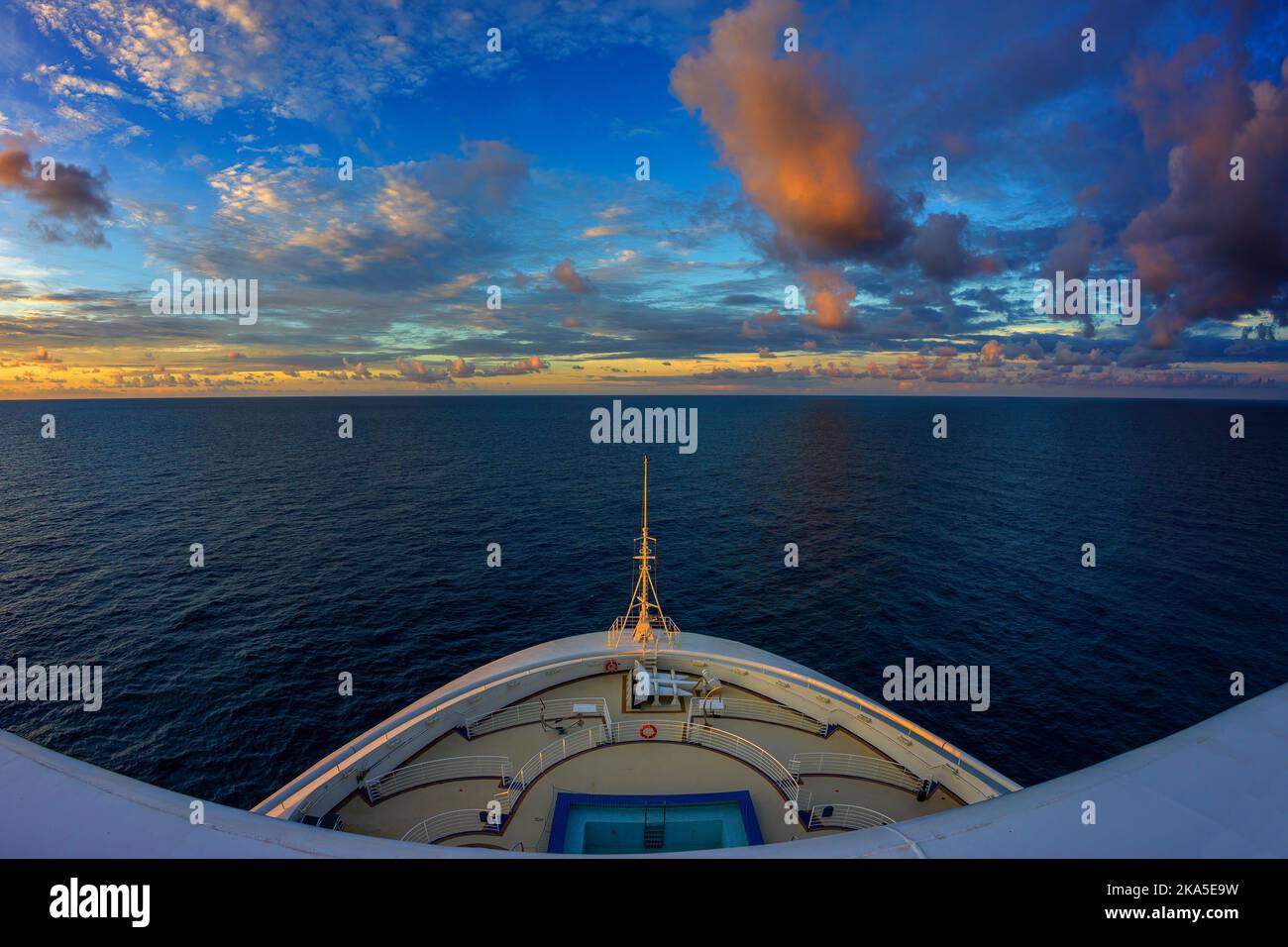 Vue en grand angle sur un noeud de paquebot de croisière au coucher du soleil avec des nuages colorés. Océan Pacifique Sud. Banque D'Images
