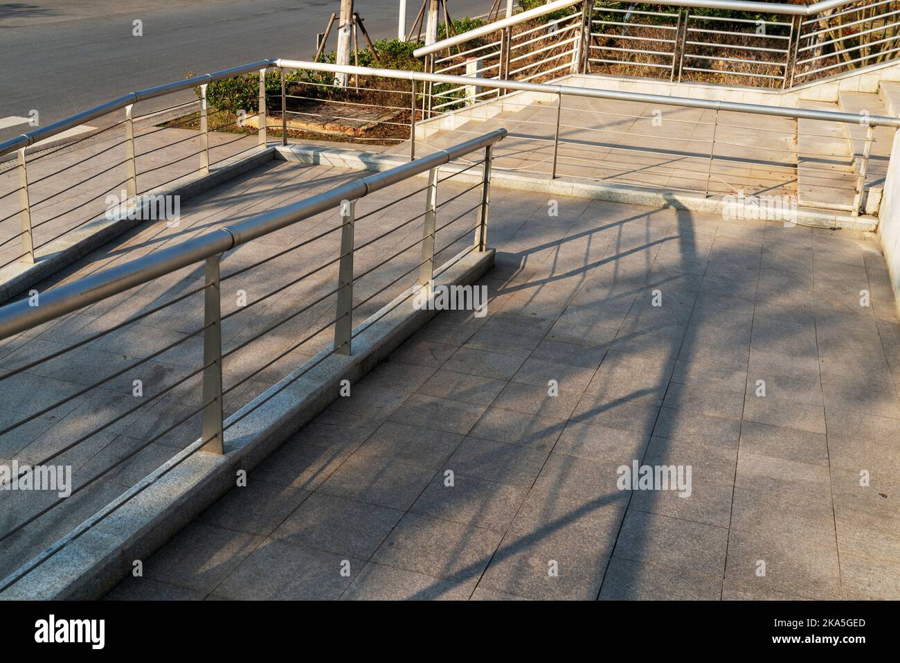 Une rampe pour fauteuil roulant, un avion incliné installé en plus ou à la place des escaliers, une passerelle pente pour personnes handicapées, personnes poussant des poussettes, des chariots Banque D'Images