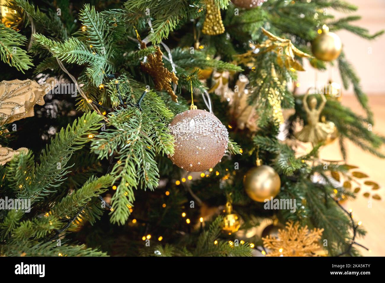 Décoration de Noël. Boules blanches et dorées accrochées aux branches de pin arbre de Noël, guirlande et ornements.Célébrez la saison de noël avec Banque D'Images