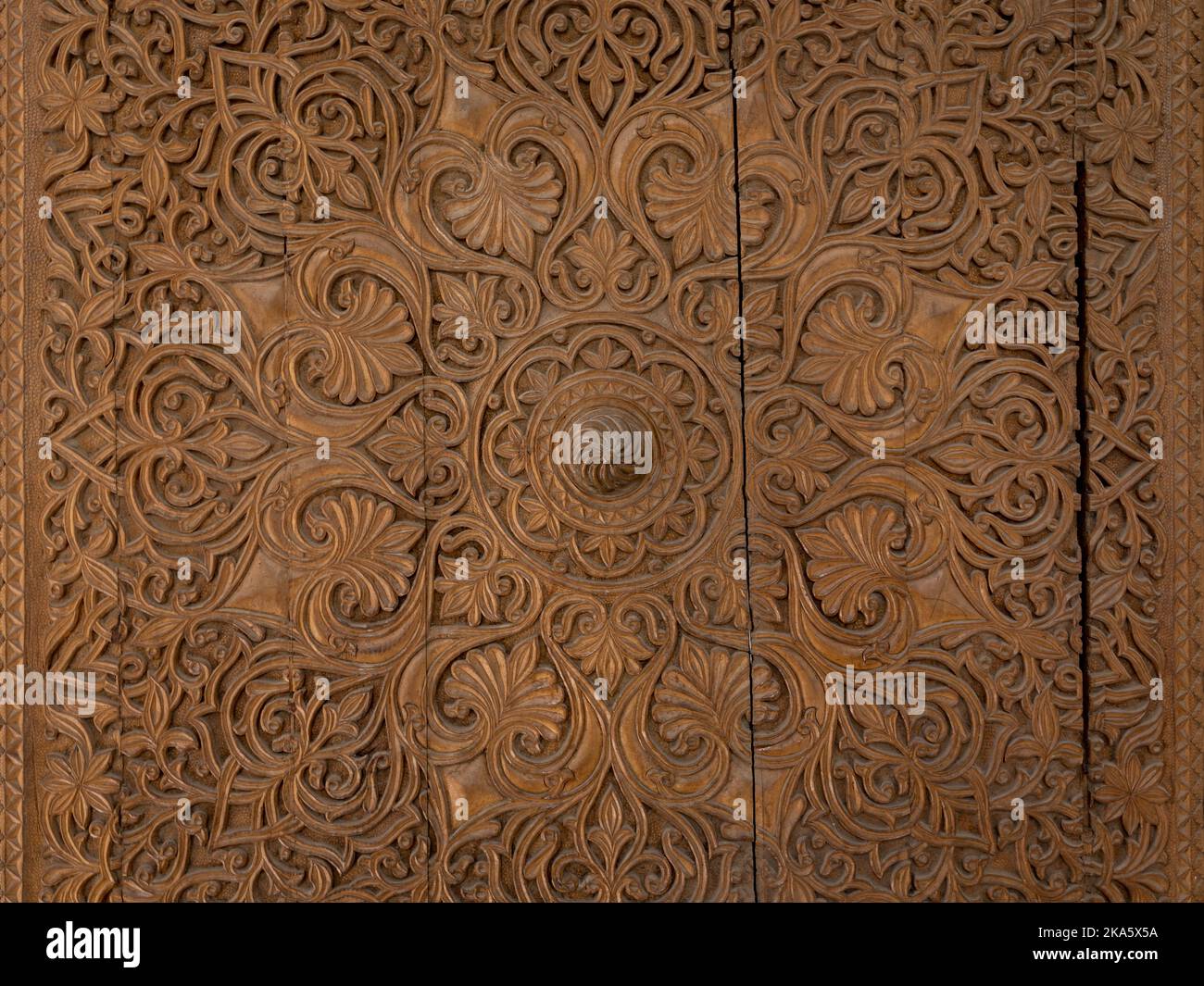 Vue rapprochée de la sculpture en bois islamique traditionnelle complexe de motifs floraux et géométriques sur l'ancienne porte, Isstalavshan, région de Sughd, Tadjikistan Banque D'Images