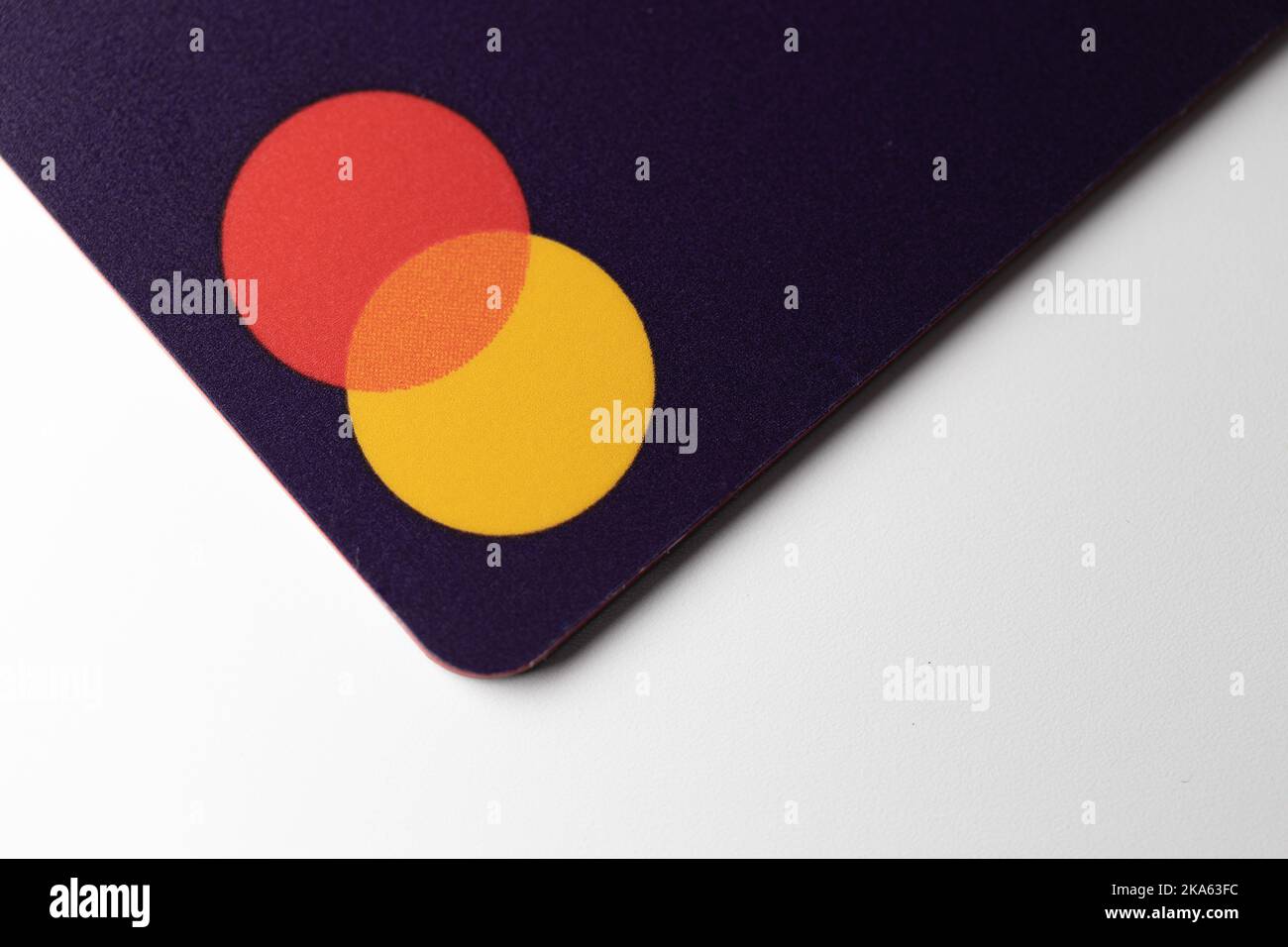 Le logo Mastercard sur une carte bancaire violette, vu lorsqu'il est placé sur un bureau blanc. Banque D'Images