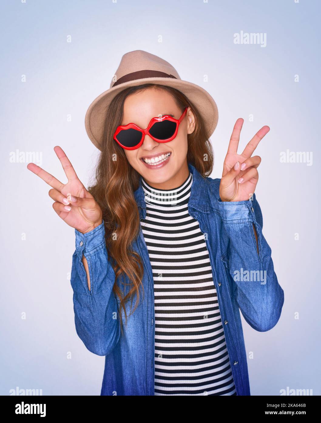 La paix, l'amour et la positivité sont ce qui se passe. Photo studio d'une belle jeune femme posant sur un fond violet. Banque D'Images